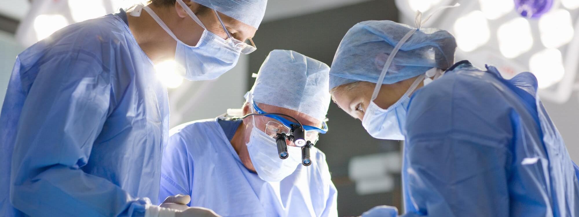 Surgeons perform an operation in theatre​